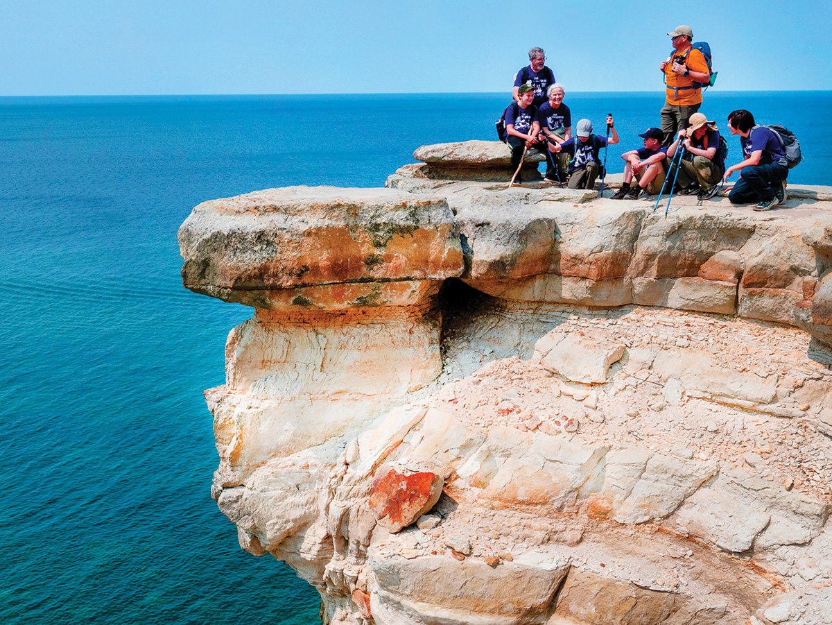 Scouts resting on a rock outcropping above Lake Superior