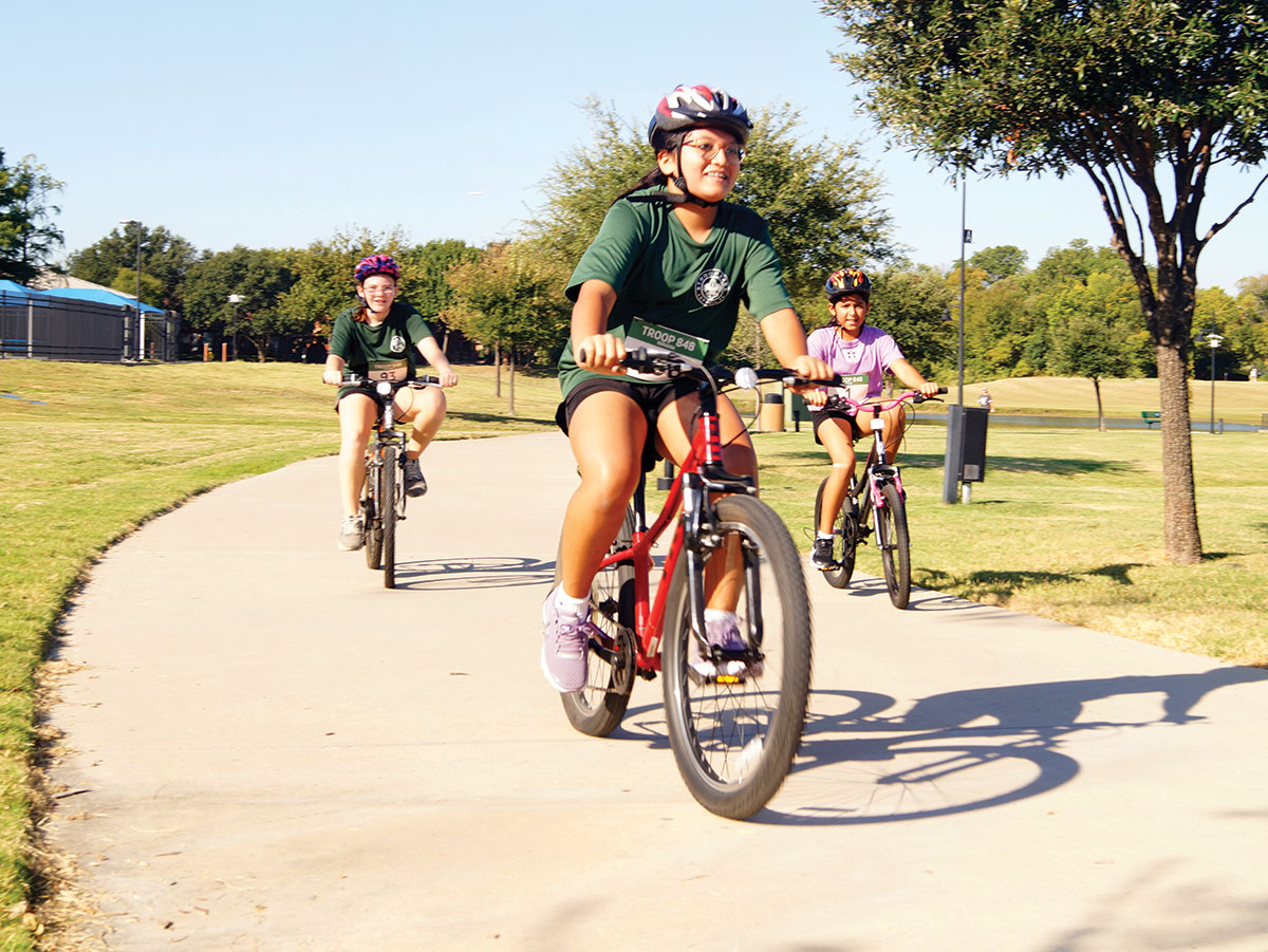 Scouts ride bicycles in a triathlon