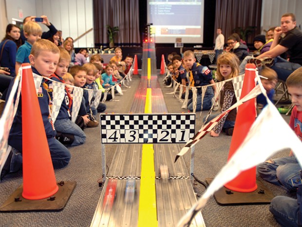 cub scouts watching a pinewood derby race