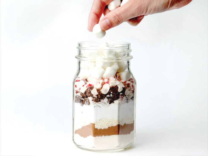 adding final layer of marshmallows to hot cocoa gift jar