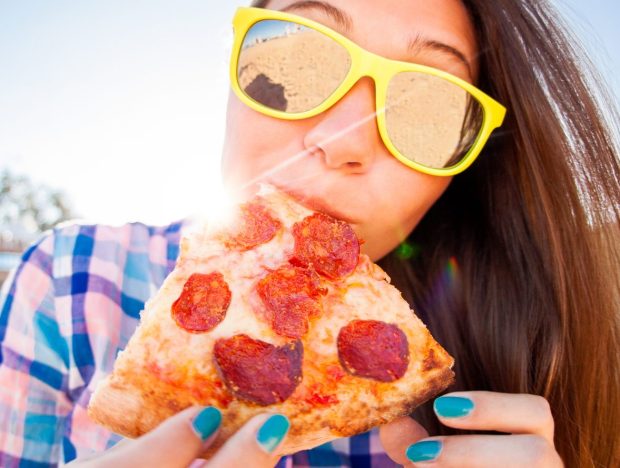 Young Woman Eating Pizza