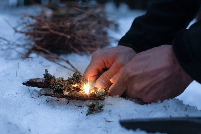 Man lighting a fire in a dark winter forest