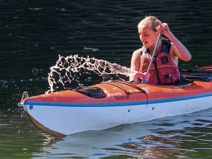 Scout uses a bilge pump to practice bailing water from kayak