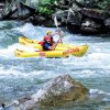 Two Scouts paddle inflatable kayaks through the rapids