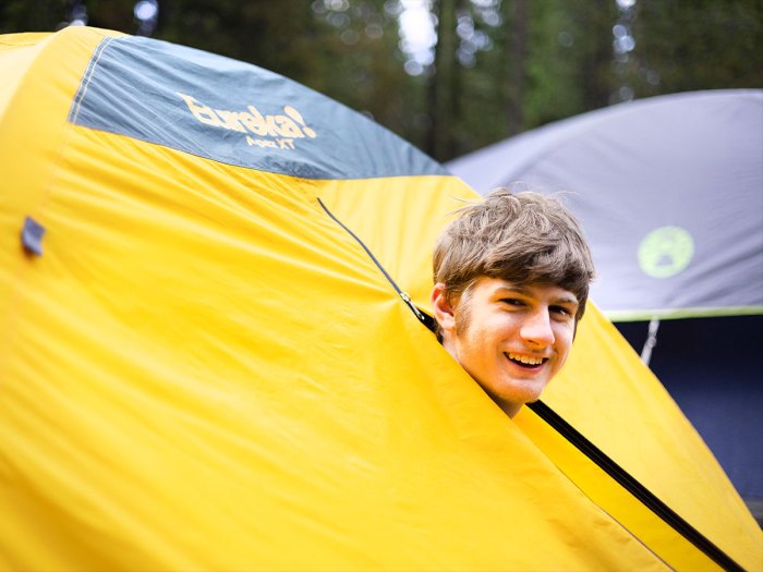 Scout poking his head out of a tent