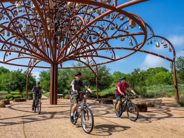 Scouts ride under a sculpture along the mission trails