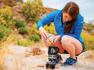 young women safely uses a camping stove