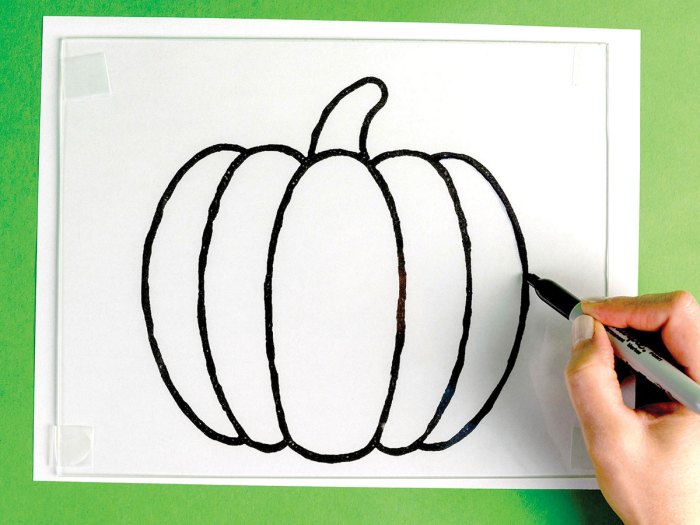 Drawing the outline of the pumpkin on glass