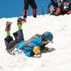 boy practicing with an ice ax to self arrest on snow