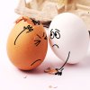 funny photo of two eggs with one comforting the other who has a cracked shell