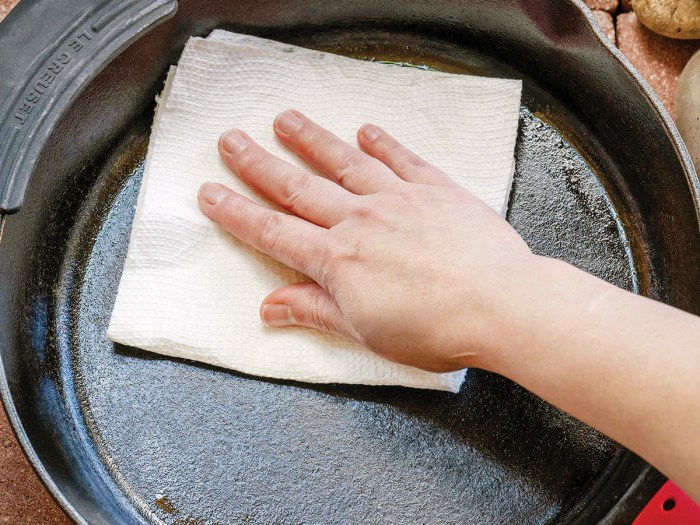 wiping excess grease from skillet