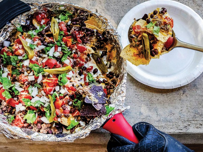 adding toppings and serving campfire nachos