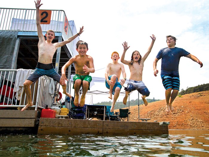 scouts jumping off a platform into the water