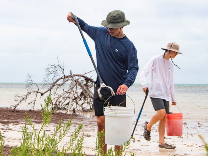 Scouts remove trash from a beach