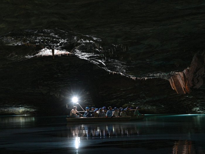 Scouts travel across an underground lake in a boat