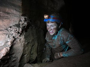 Scout crawling through cave