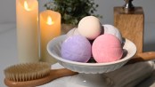 homemade bath bombs in a bowl surrounded by relaxing bath supplies