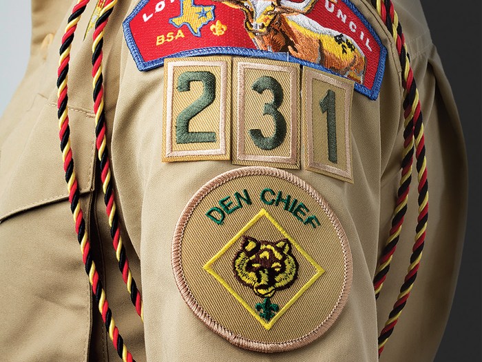close up of the den chief patch on the sleeve of a Scouts BSA uniform